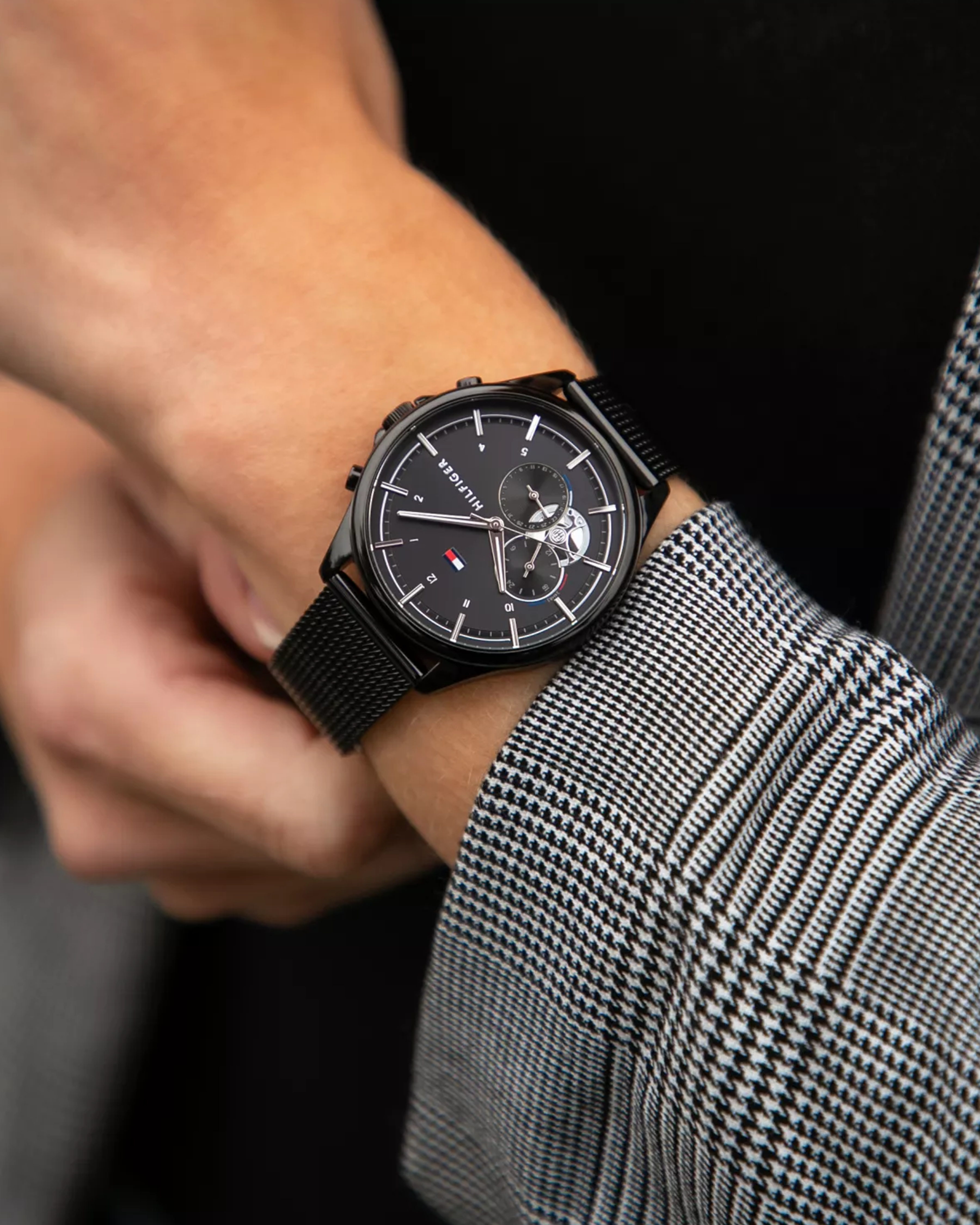 Black watch on a person's wrist with a blurred background